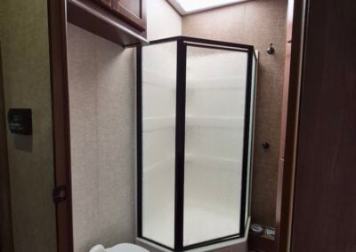 Bathroom showing toilet, shower and cabinets.