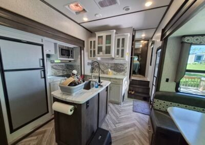 Image of Kitchen area shows refrigerator, island countertop, cabinets and additional counter space.