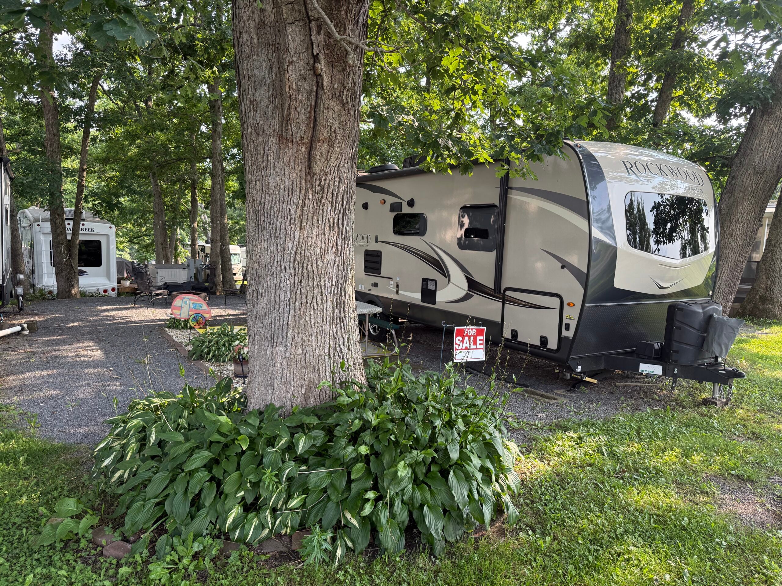 Outside of Rockwood Travel Trailer with Tree and Hostas