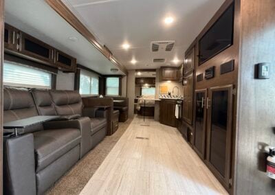 Couch, table and chairs dinette set, kitchen sink, tv, and main bed