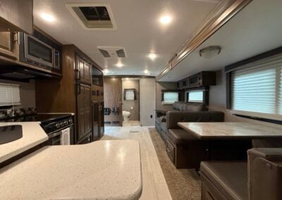 Dinette Set, Couch, and Stove with bathroom toilet in the far view of the photo