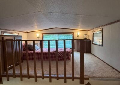 loft with bed and railing