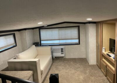 loft of park model with couch and entertainment center